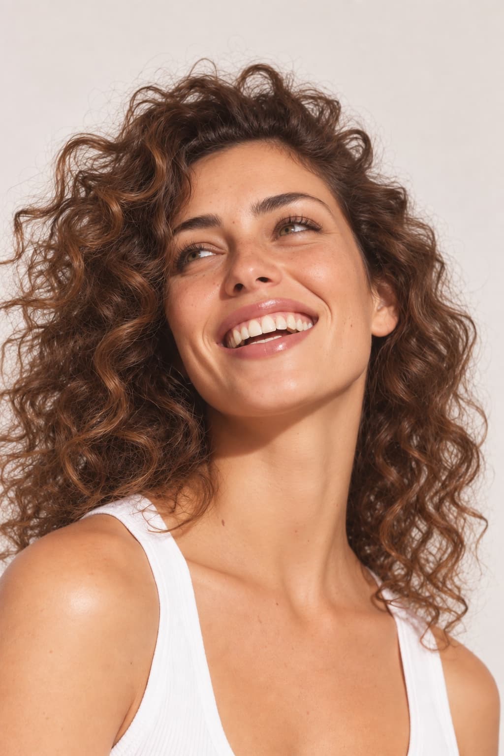 Curly-haired woman with a wide, natural smile