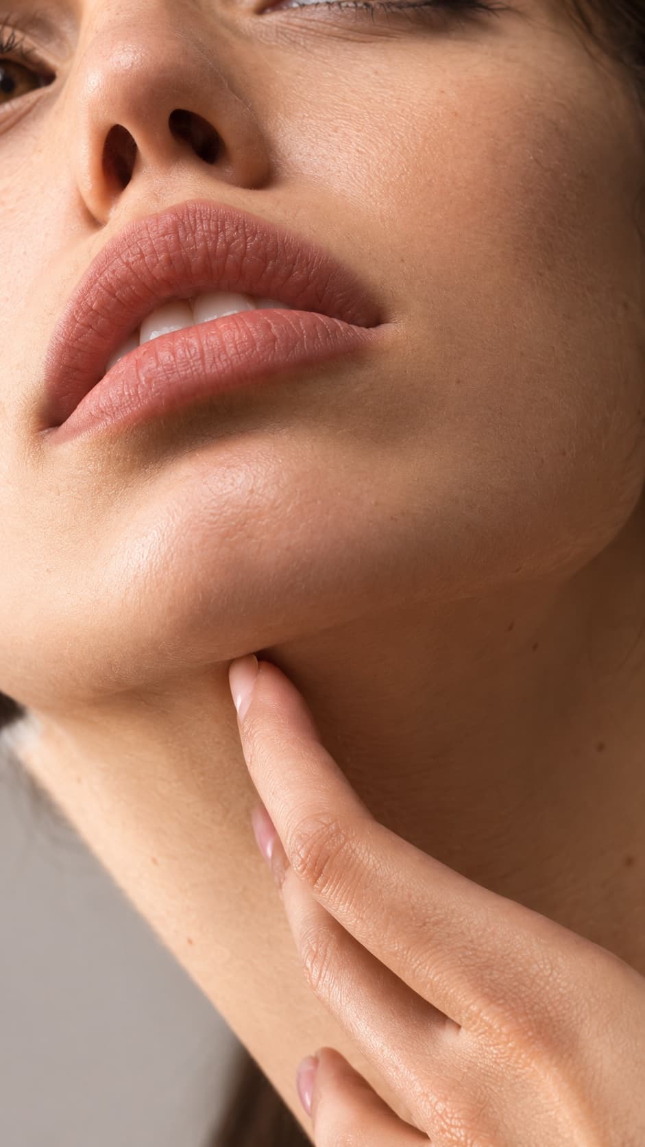 Close-up of a woman's lips, chin and neck with smooth contours